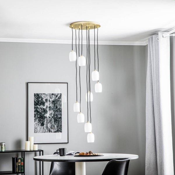 Mehrflammige Pendelleuchte über einem Esstisch in einem Esszimmer.