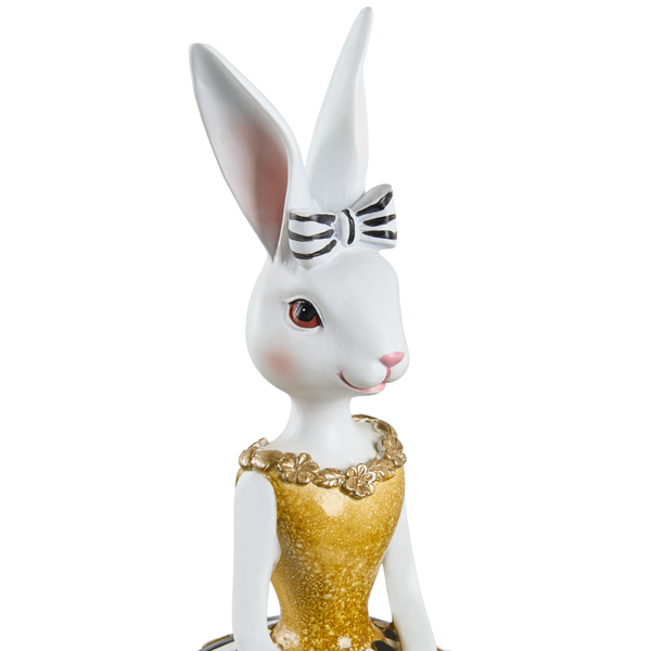 Weiße Dekofigur Hase im goldfarbenen Kleid mit gestreifter Schleife, Osterdekoration aus Kunststein.