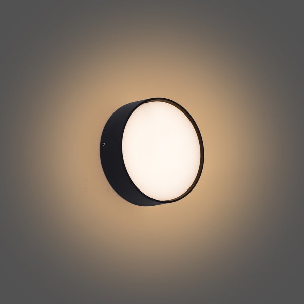 Runde Außenwandleuchte in Schwarz mit warmweißem Licht.