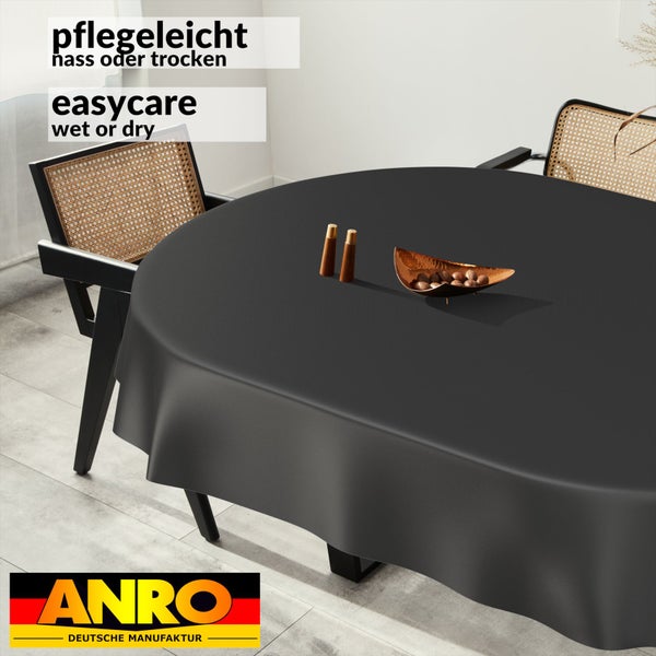 Runde, pflegeleichte Wachstischdecke in Anthrazit auf einem Esstisch, nass oder trocken abwischbar. ANRO Logo.