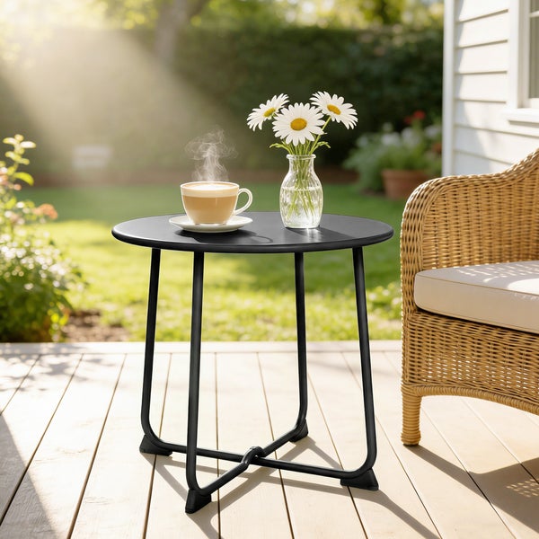 Runder schwarzer Gartentisch aus Metall, dekoriert mit zwei Tassen und einer Blumenvase.