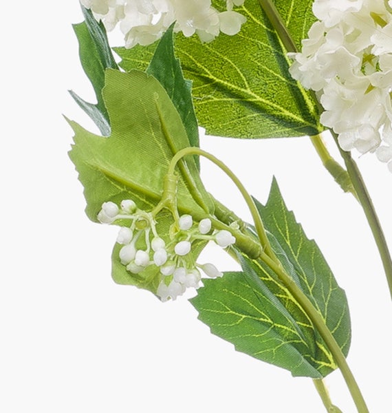 Verzweigter grüner Stiel einer Kunstpflanze mit brauner Basis.