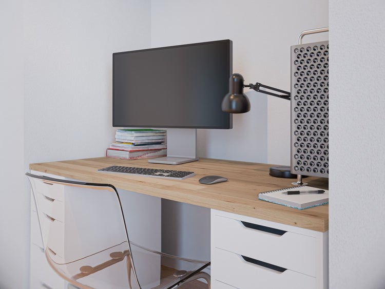Heller, organisierter Arbeitsplatz mit einem Schreibtisch aus Holz, einem transparenten Stuhl, Schubladen und Computer-Ausstattung.
