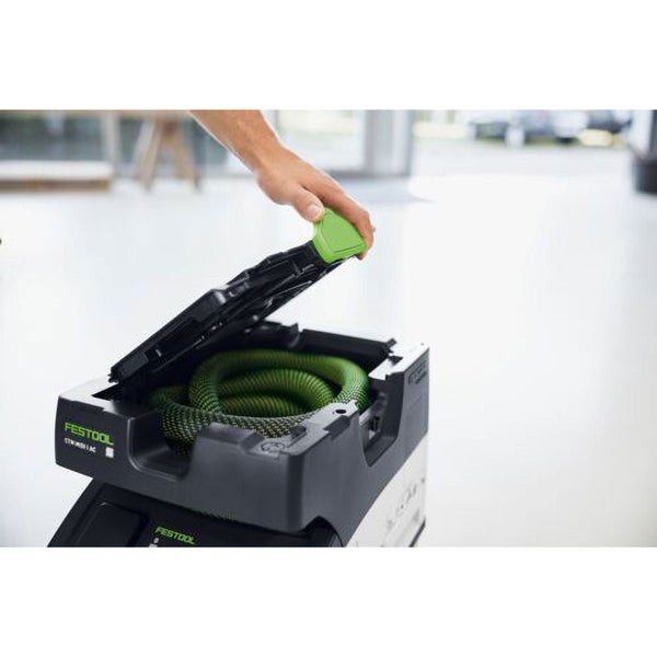 Hand öffnet das Schlauchdepot eines Festool Absaugmobils mit darin verstautem Saugschlauch.