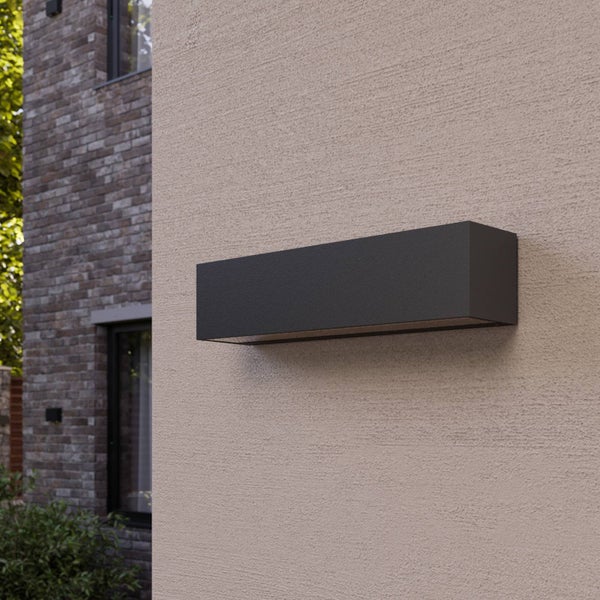 Rechteckige Außenwandleuchte in Anthrazit an der strukturierten Fassade eines modernen Hauses.