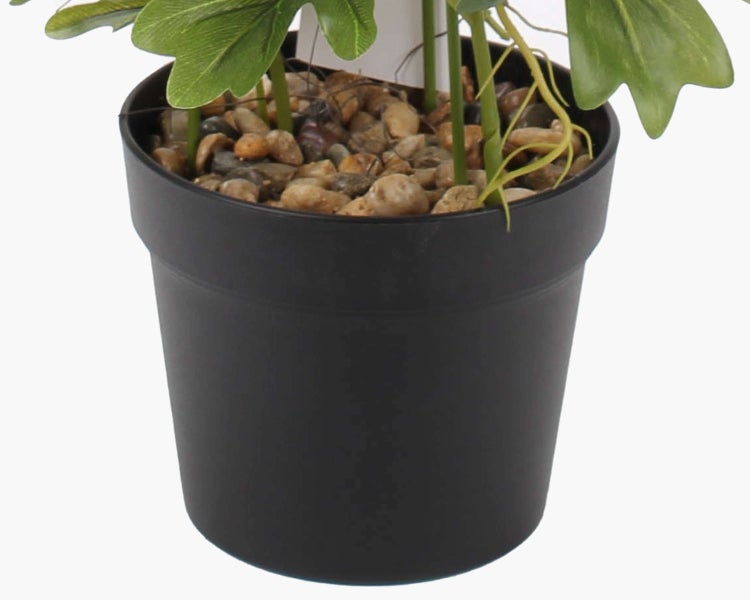 Künstlicher grüner Zweig mit gezackten Blättern und Kunststoffstielen.