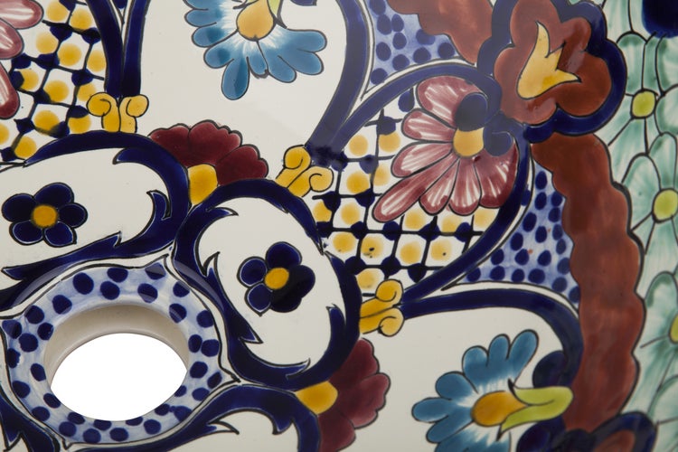 Nahaufnahme eines Waschbeckens mit blauem, gelbem und rotem Blumendekor