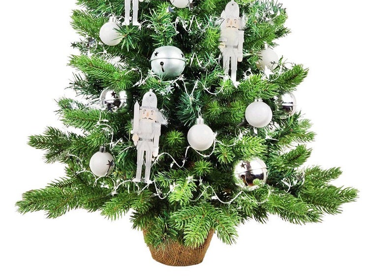 Weihnachtsbaum mit Nussknacker Anhaengern und Christbaumkugeln dekoriert in einem Jutetopf stehend