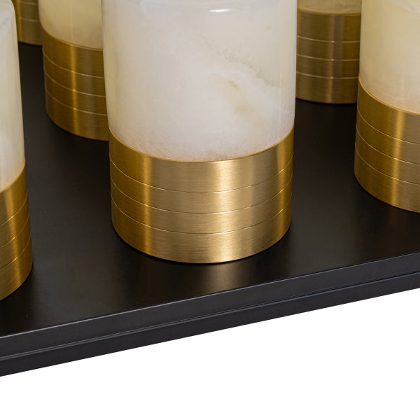 Nahaufnahme von zylindrischen Lampen mit Marmoreffekt und gebürstetem Metallsockel auf einer schwarzen Basisplatte.