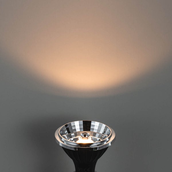 LED-Leuchtmittel GU10 mit warmweißem Lichtstrahl an einer Wand.