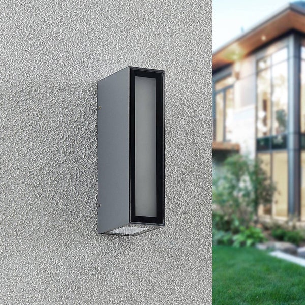 Moderne rechteckige Außenwandleuchte aus Metall an einer strukturierten Hauswand im Außenbereich.