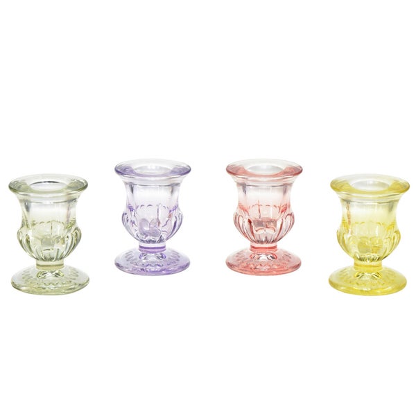 Vier verzierte Kerzenständer aus Glas in verschiedenen Farben.