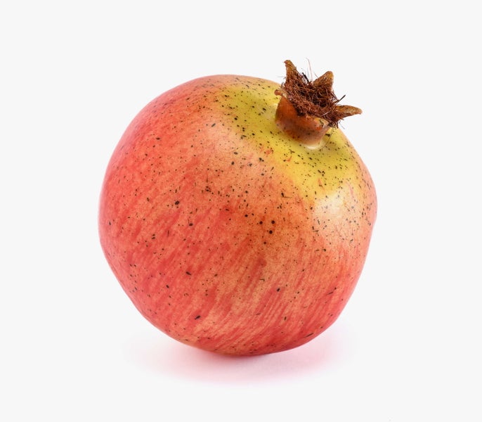 Ganze Frucht eines Granatapfels mit rötlicher Schale und markantem Blütenansatz.