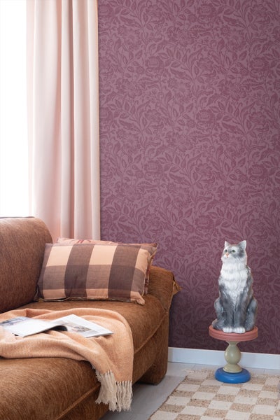 Wohnzimmer mit Sofa, gemusterter Tapete und Dekoration