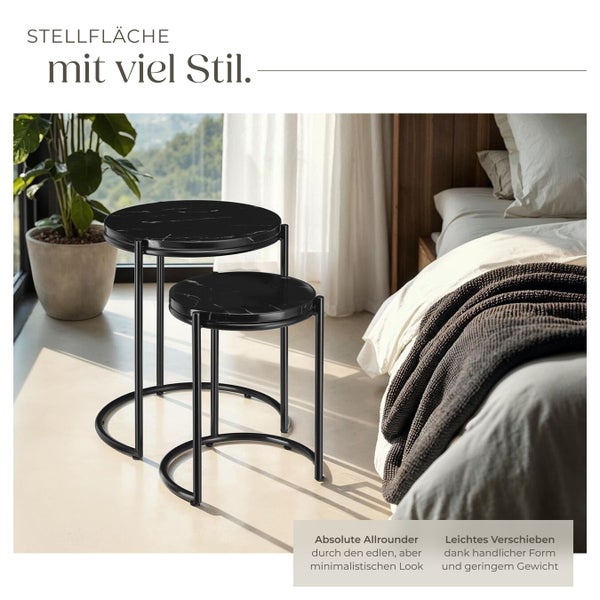 Zwei runde Beistelltische mit schwarzer Marmorplatte und Metallgestell im Schlafzimmer.