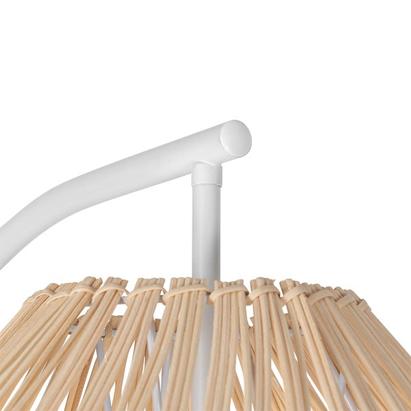 Detailaufnahme einer Lampe mit Lampenschirm aus Rattan und weißem Gestell.
