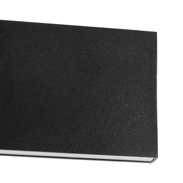 Detailansicht einer schwarzen Wandleuchte mit strukturierter Oberfläche und Lichtauslass an der Unterseite.