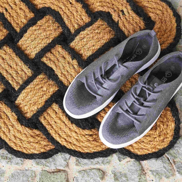 Fußmatte aus Kokosfaser mit Webmuster und ein Paar Schuhe