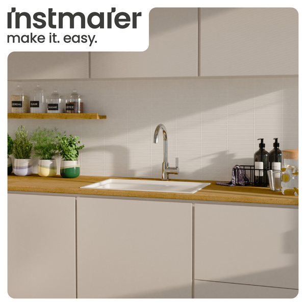 Helle, moderne Küche mit Einbauspüle und Chromarmatur auf einer Holzarbeitsplatte, ergänzt durch Kräutertöpfe und ein Instmaier Logo.