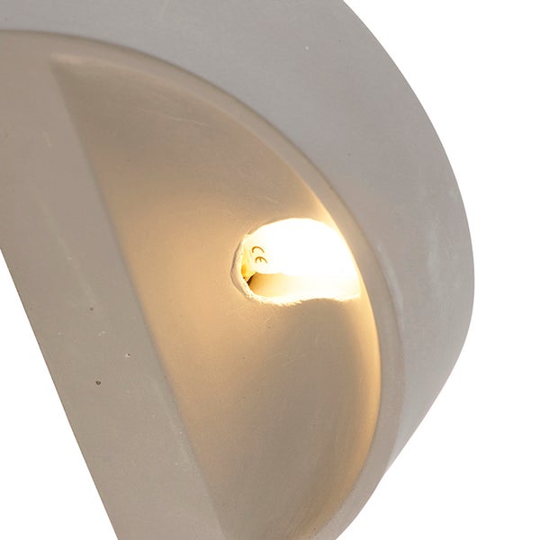 Nahaufnahme einer Betongusswandleuchte mit Glühbirne