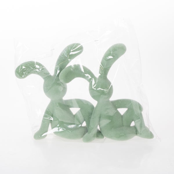 Zwei grüne Hasenfiguren in einer transparenten Plastikverpackung.