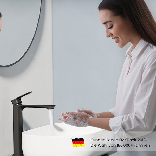 Frau wäscht sich die Hände an einem Waschbecken mit einer schwarzen Armatur.