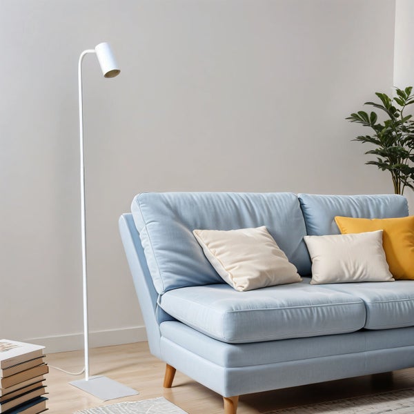 Wohnzimmer mit blauem Sofa, Kissen, Stehlampe und Zimmerpflanze