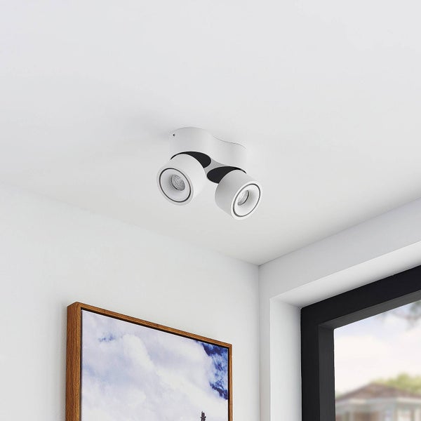 Zweiflammiger Deckenstrahler in Weiß, montiert an einer hellen Decke in einem hellen, modern eingerichteten Raum.