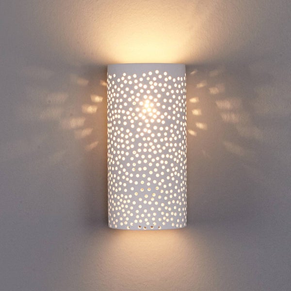 Wandleuchte mit punktförmigem Muster beleuchtet eine Wand