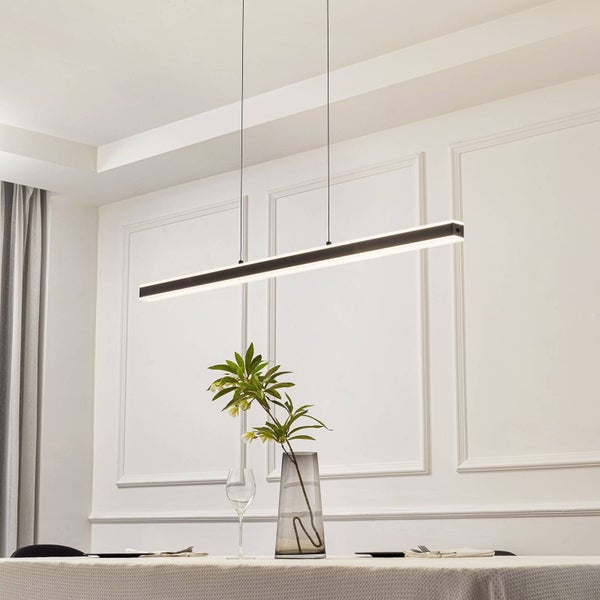 Moderne lineare LED-Pendelleuchte über einem gedeckten Esstisch in einem hellen Raum mit dekorativen Wandleisten.