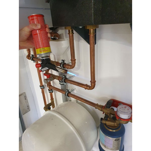 Handwerker lötet Kupferrohre einer Sanitärinstallation mit einem Rothenberger Gaslötgerät.