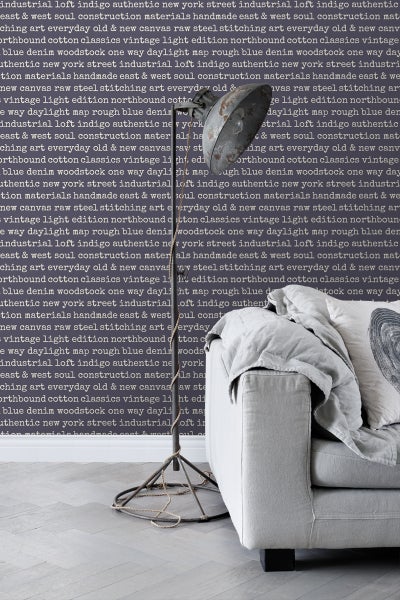 Stehlampe im Industrial-Stil neben Sofa mit Kissen und Decke