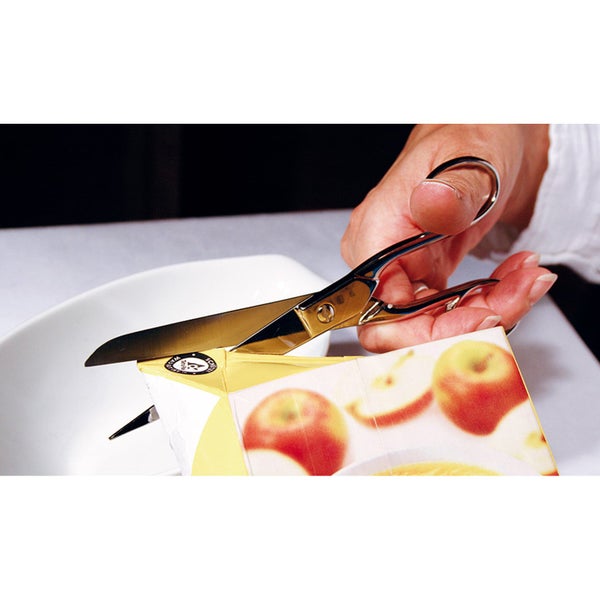 Haushaltsschere aus Edelstahl schneidet eine Saftverpackung aus Karton auf.