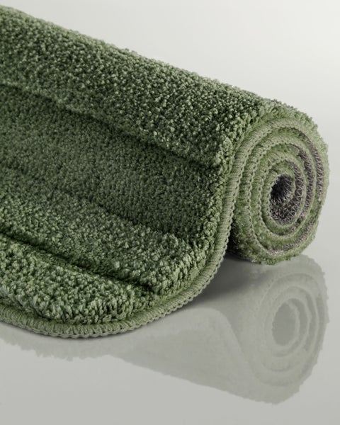 Ein aufgerollter Badteppich mit strukturierter Oberfläche aus flauschigem Textilmaterial.