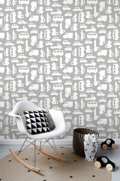 Kinderzimmer mit Tapete mit Automotiven, Schaukelstuhl, Kissen, Teppich, Korb und Spielzeugautos