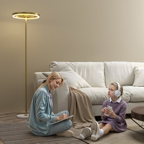 Wohnzimmer mit Stehleuchte, Sofa und zwei Personen auf einem Teppich