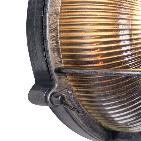 Nahaufnahme einer ovalen Außenwandleuchte im Vintage-Look mit geriffeltem Glas und Metallrahmen.