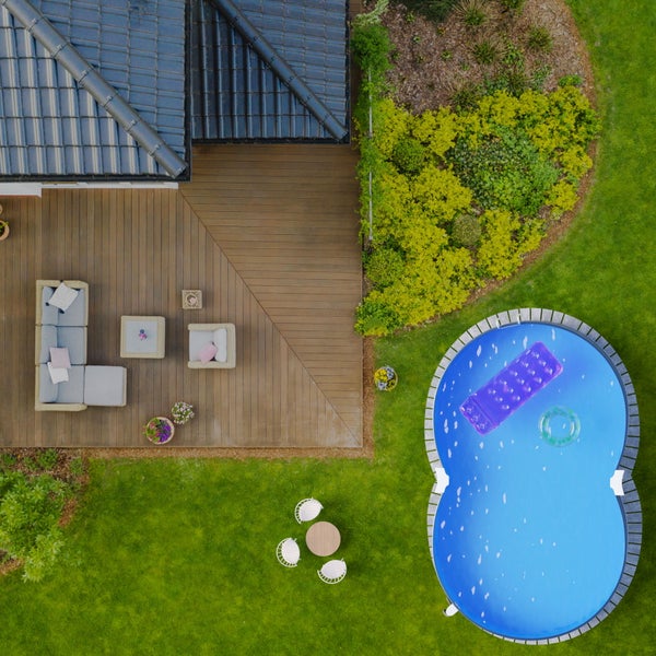 Draufsicht auf ein Haus mit Terrasse, Gartenmöbeln und Pool