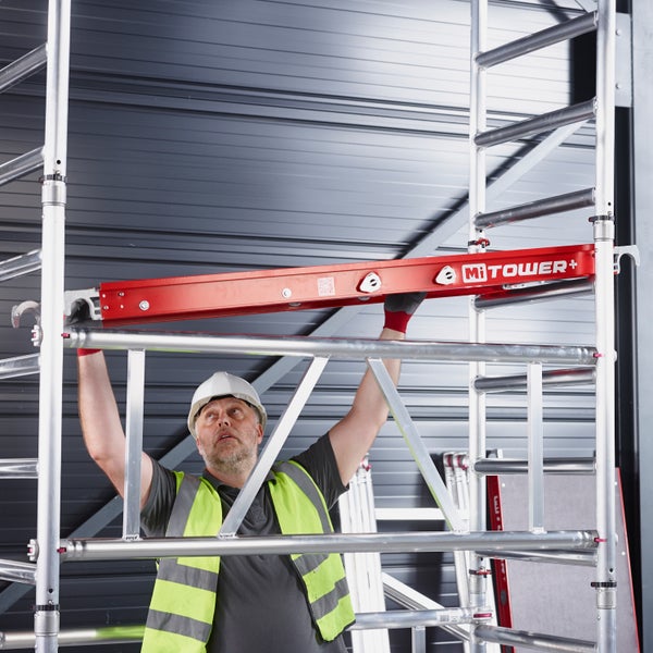 Mann montiert ein fahrbares Gerüst von MiTOWER Plus