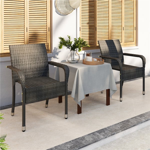 Terrassenszene mit zwei Rattan-Armlehnstühlen und einem kleinen Tisch mit Tischdecke