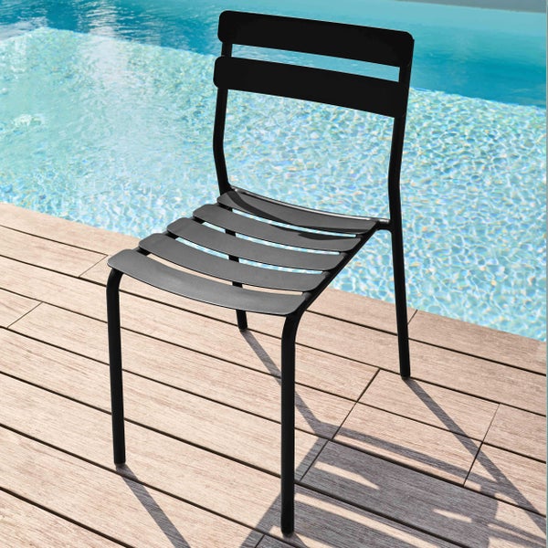 Schwarzer Gartenstuhl aus Metall mit Lamellen-Design auf einer Holzterrasse neben einem Pool.