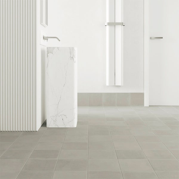 Modernes Badezimmer mit hellen quadratischen Bodenfliesen, einem freistehenden Marmorwaschbecken und einer gerillten Wandverkleidung.