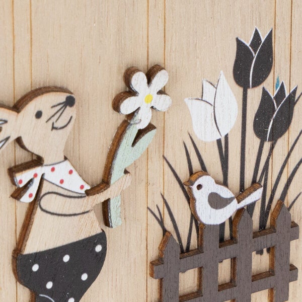 Dekorative Holzfigur mit Osterhase und Blume als Frühlingsdekoration auf einer Holzoberfläche