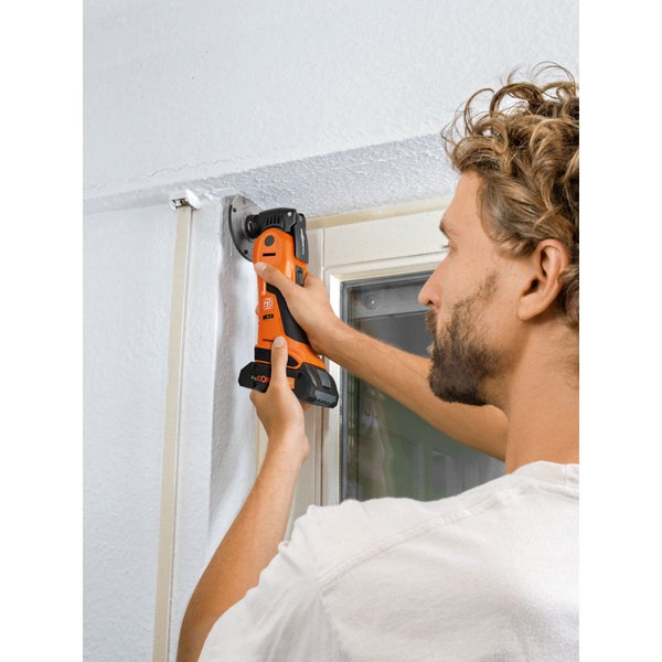 Akku-Multitool Fein Multimaster beim Schleifen eines Holz-Fensterrahmens auf einer Werkbank.