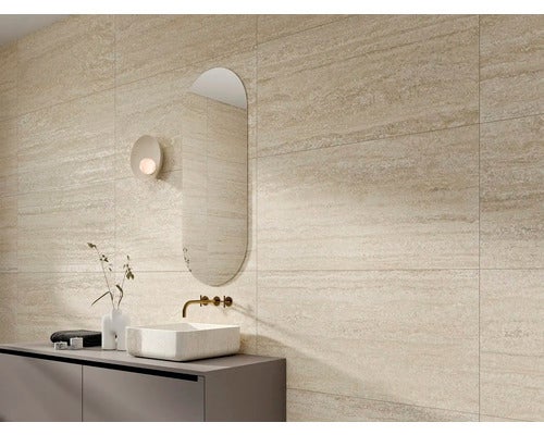 Helles Badezimmer mit Wandfliesen in Steinoptik, Waschtisch und Spiegel