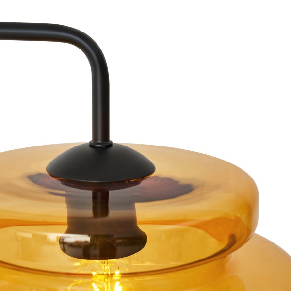 Detailaufnahme einer gelben Glaspendelleuchte mit schwarzer Halterung