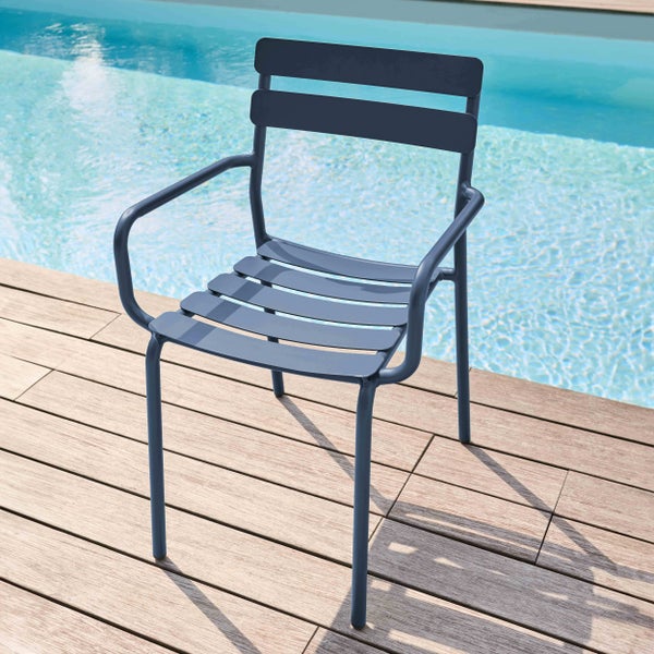 Moderner Gartenstuhl aus Metall mit Armlehnen und Lattendesign auf einer Holzterrasse an einem Pool.