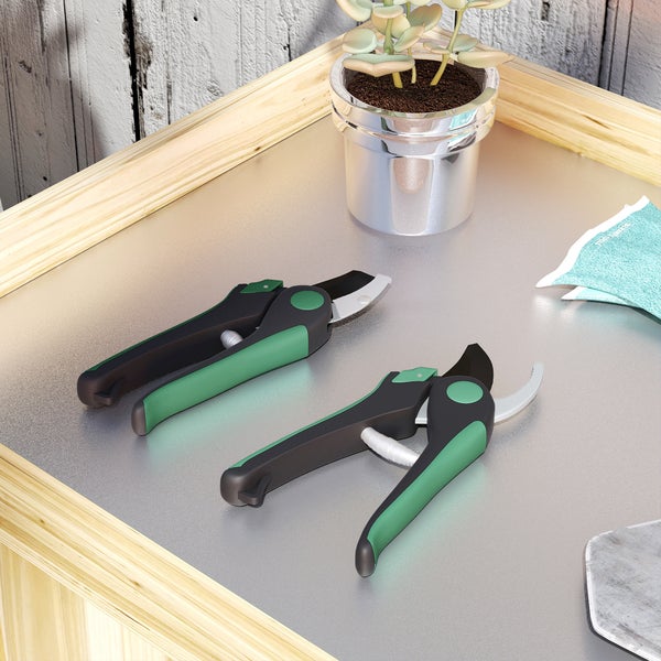 Zwei Gartenscheren neben Topfpflanze auf Tisch