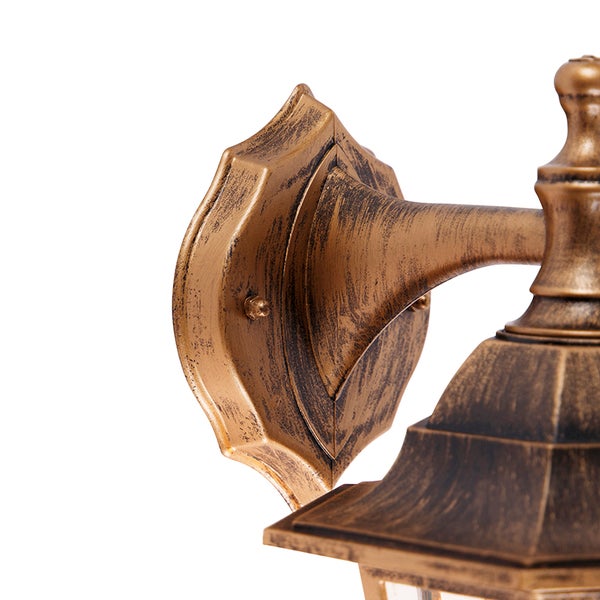 Detailaufnahme der Wandhalterung einer Außenwandleuchte aus Metall in Gold-Antik.