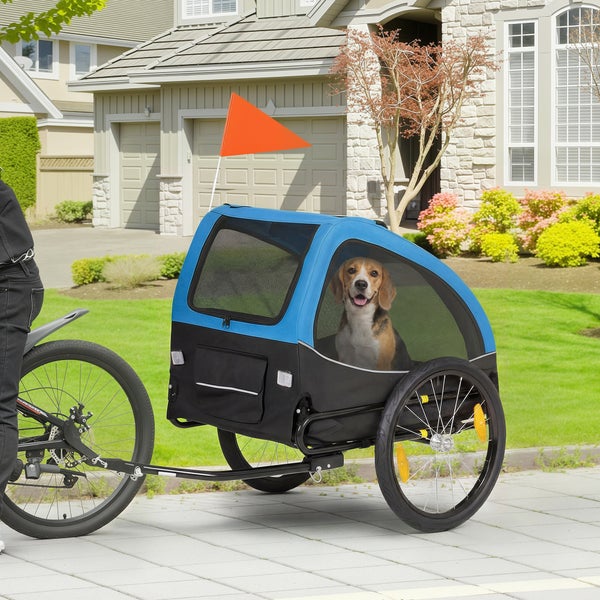 Blau-schwarzer Fahrradanhänger für Hunde mit einem Beagle darin, an einem Fahrrad befestigt, inklusive Sicherheitsfahne und Netzfenstern.